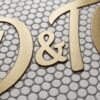 Brushed brass logo lettering inlaid into penny round mosaic